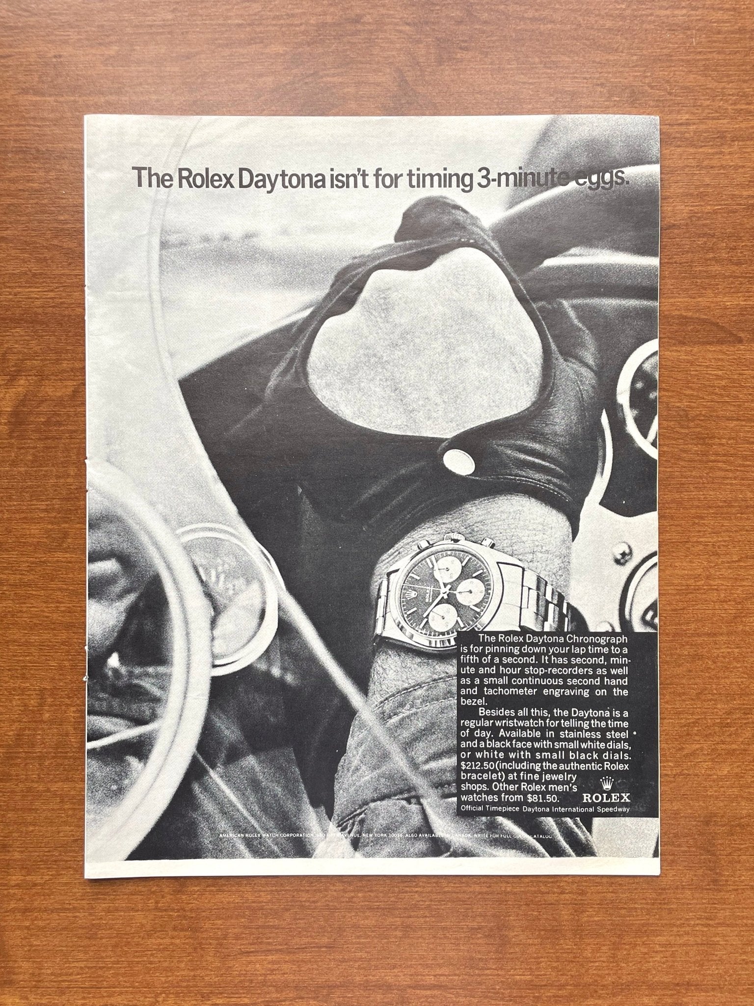 Publicité Rolex Daytona de 1967 sur fond bois, avec un volant de course et le slogan 'The Rolex Daytona isn't for timing 3-minute eggs.'