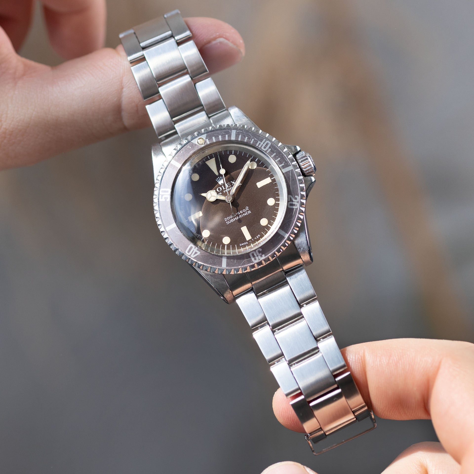 Rolex Submariner 5513 tropicale tenue en main, cadran marron et aiguilles tritium